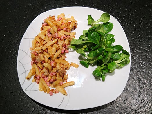 Assiette de spätzle au lard accompagnés de mâche fraîche